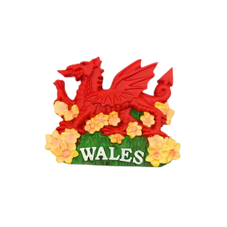 A magnet featuring the national emblem of Wales, which consists of a red dragon on a green and yellow background with a stylized 'W' in the center, surrounded by yellow flowers.